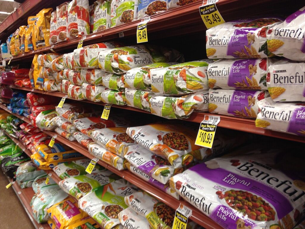 Dog food aisle with rows of dry food bags on store shelves