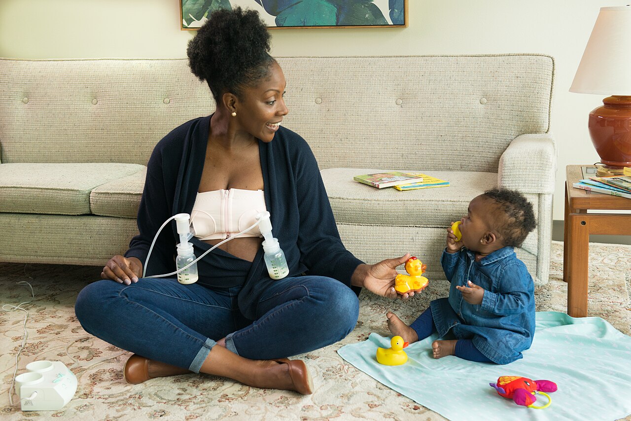Mother using an electric breast pump